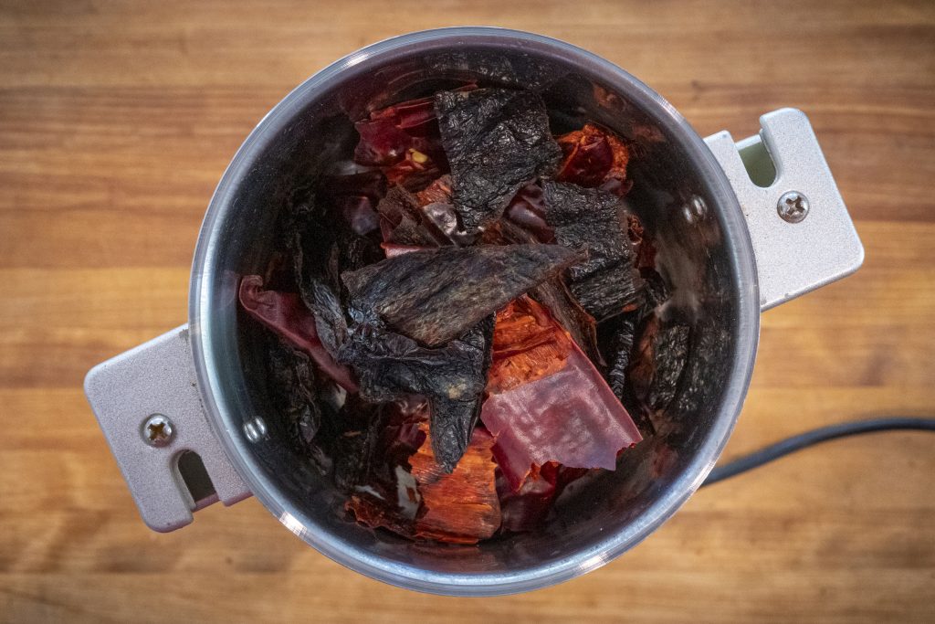 Grinding dried chiles into powder.